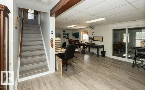 Spacious lower-level room featuring wood-finish flooring, a drop ceiling with recessed lighting, and white walls - 27132A Twp Rd 632, Rural Westlock County, AB - Indoor Photo Showing Other Room
