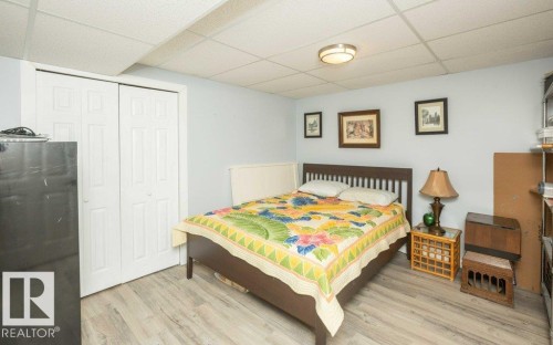 Room featuring a light grey wall color, wood-finish flooring, and a white bi-fold closet door - 27132A Twp Rd 632, Rural Westlock County, AB - Indoor Photo Showing Bedroom