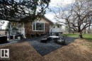 Exterior featuring stone and siding finishes, a spacious black patio area, white window trim, and a fenced perimeter - 27132A Twp Rd 632, Rural Westlock County, AB  - Outdoor 