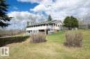 Exterior residence featuring light-colored siding, a covered porch, and a second-story balcony - 27132A Twp Rd 632, Rural Westlock County, AB  - Outdoor With Deck Patio Veranda 