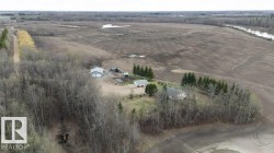 Rural property featuring a main residence, two outbuildings, and cultivated land - 