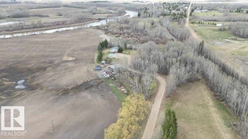 Expansive land parcel featuring multiple structures, cleared agricultural fields, and a river frontage - 27132A Twp Rd 632, Rural Westlock County, AB - Outdoor With View