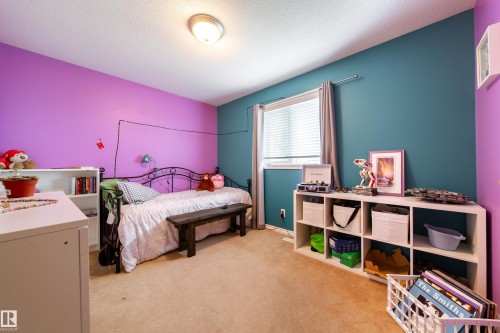 This room features carpeted flooring, a window with blinds, and a built-in light fixture - 4 Windrose Drive, Leduc, AB - Indoor Photo Showing Bedroom