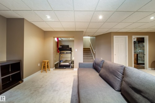 This versatile interior space features carpeting, recessed lighting, and access to a staircase - 4 Windrose Drive, Leduc, AB - Indoor