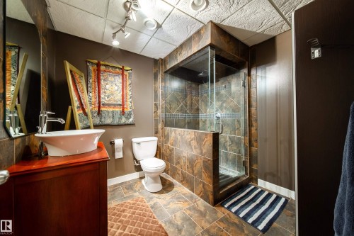 Bathroom featuring a glass-enclosed shower with tiled walls, a toilet, and a vanity with a vessel sink - 4 Windrose Drive, Leduc, AB - Indoor Photo Showing Bathroom