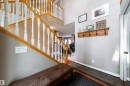 Inviting entryway featuring a wooden staircase with white balusters, a wooden coat rack, and light gray walls - 4 Windrose Drive, Leduc, AB  - Indoor Photo Showing Other Room 