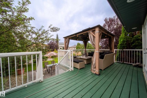 Spacious outdoor deck with green flooring, white railings, and a covered seating area - 4 Windrose Drive, Leduc, AB - Outdoor With Deck Patio Veranda With Exterior