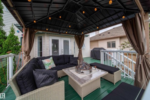 The property features an outdoor deck with a dark green surface, a gazebo with a dark roof, and string lighting - 4 Windrose Drive, Leduc, AB - Outdoor With Deck Patio Veranda With Exterior