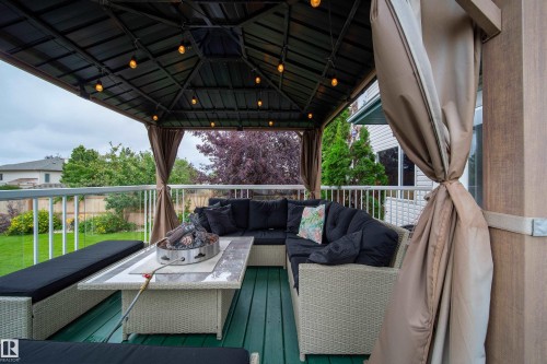 This outdoor living area features a covered deck with a dark-colored gazebo structure, complete with string lights - 4 Windrose Drive, Leduc, AB - Outdoor With Deck Patio Veranda With Exterior