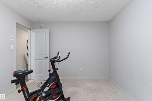 Neutral-toned room featuring light-colored carpeting and smooth, painted walls - 221 344 Windermere Road, Edmonton, AB - Indoor Photo Showing Gym Room