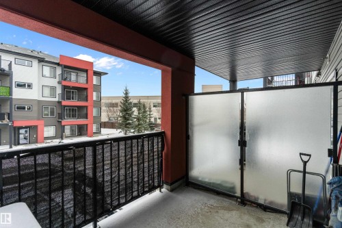 Expansive covered balcony featuring a black metal railing and frosted privacy panels - 221 344 Windermere Road, Edmonton, AB - Outdoor With Balcony With Exterior