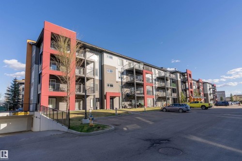 Multi-story building featuring modern red, grey, and white facade accents - 221 344 Windermere Road, Edmonton, AB - Outdoor With Balcony With Facade