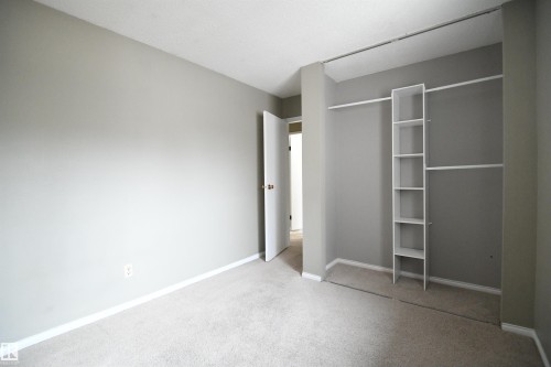 Both the second and third bedrooms are nicely sized, with generous closets.  This one is at the rear of the  of the unit, above the kitchen, and looks out over the rear yard and deck - 6706 36A Avenue, Edmonton, AB - Indoor Photo Showing Other Room