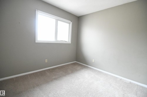 Both the second and third bedrooms are nicely sized, with generous closets.  This one is at the rear of the  of the unit, above the kitchen, and looks out over the rear yard and deck - 6706 36A Avenue, Edmonton, AB - Indoor Photo Showing Other Room