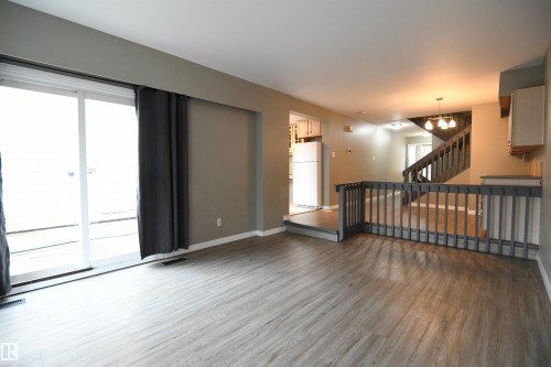 The open layout really does provide some great options for furniture placement, and makes for a great family and entertaining space.  The patio doors open on to the private rear deck and yard - 6706 36A Avenue, Edmonton, AB - Indoor Photo Showing Other Room