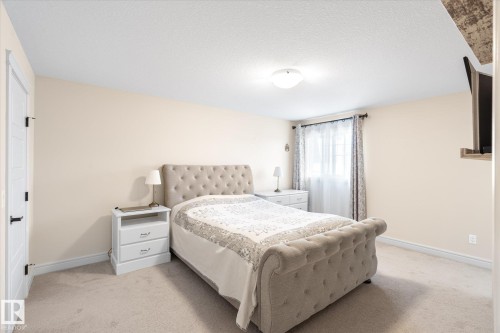 Bedroom featuring light-toned carpeting, neutral wall paint, and a built-in light fixture - 6864 Evans Wynd, Edmonton, AB - Indoor Photo Showing Bedroom