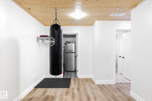 Spacious room featuring wood-finish flooring and a natural wood plank ceiling - 6864 Evans Wynd, Edmonton, AB - Indoor Photo Showing Other Room