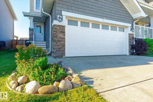 Attached two-car garage featuring a white door with upper window panels - 6864 Evans Wynd, Edmonton, AB - Outdoor