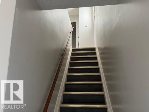 Stairwell featuring light gray painted walls, a dark wood-finish handrail, and stairs with dark treads and light risers - 6117 120 Avenue, Edmonton, AB - Indoor Photo Showing Other Room