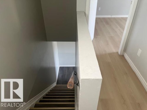 Light wood-finish flooring extending through the hallway - 6117 120 Avenue, Edmonton, AB - Indoor Photo Showing Other Room