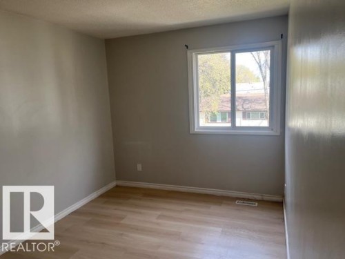 Room featuring wood-finish flooring, light gray walls, and white baseboards - 6117 120 Avenue, Edmonton, AB - Indoor Photo Showing Other Room