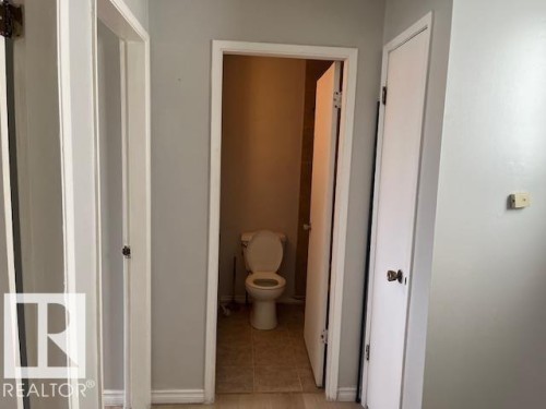Hallway featuring light gray painted walls and multiple white interior doors - 6117 120 Avenue, Edmonton, AB - Indoor Photo Showing Bathroom