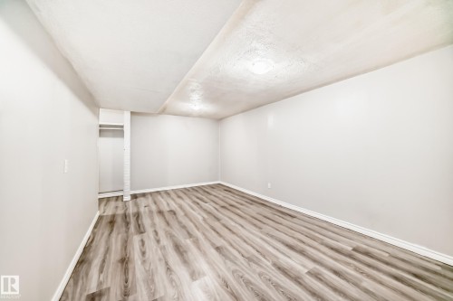 Spacious room featuring wood-finish flooring, light gray walls, white trim, and recessed lighting - 6117 120 Avenue, Edmonton, AB - Indoor Photo Showing Other Room
