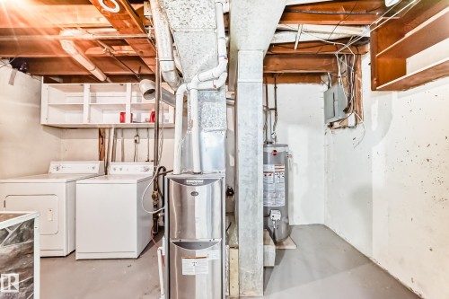 Utility area featuring a furnace, water heater, and exposed ceiling joists - 6117 120 Avenue, Edmonton, AB - Indoor Photo Showing Laundry Room