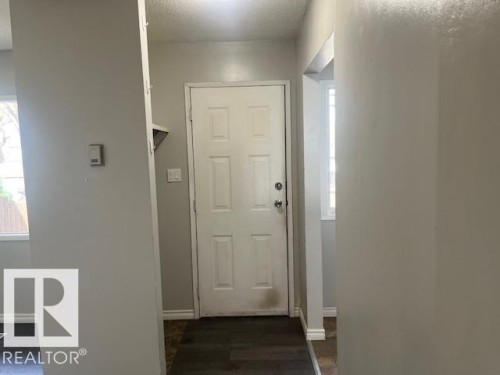 Entryway featuring a paneled door, light gray walls, dark wood-finish flooring, and white baseboards - 6117 120 Avenue, Edmonton, AB - Indoor Photo Showing Other Room