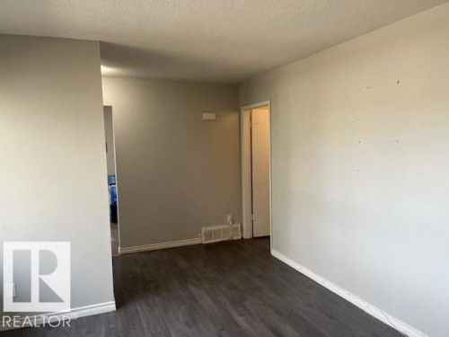 Interior space featuring wood-finish flooring, light grey painted walls, white baseboards, and a white ceiling - 6117 120 Avenue, Edmonton, AB - Indoor Photo Showing Other Room