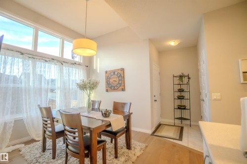 Dining area with a drum pendant light fixture and wood-finish flooring - 1766 Dumont Crescent Sw, Edmonton, AB - Indoor Photo Showing Dining Room