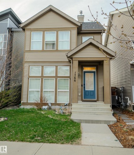 Two-story residence featuring light brown horizontal siding and a dark blue front door with glass paneling - 1766 Dumont Crescent Sw, Edmonton, AB - Outdoor
