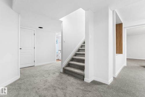 Carpeted staircase with white risers and a contemporary vertical wood slat accent - 362 Blackburn Drive E, Edmonton, AB - Indoor Photo Showing Other Room