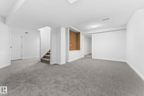 Spacious room featuring neutral grey carpeting and freshly painted white walls - 362 Blackburn Drive E, Edmonton, AB - Indoor Photo Showing Other Room