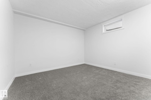 Spacious room featuring neutral paint, gray carpeting, white trim, and a high-set window with blinds - 362 Blackburn Drive E, Edmonton, AB - Indoor Photo Showing Other Room