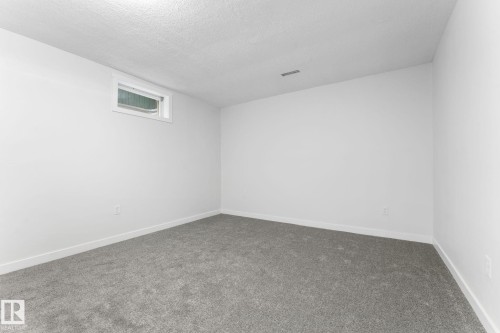Spacious room featuring light gray carpeting, crisp white walls, and a recessed window - 362 Blackburn Drive E, Edmonton, AB - Indoor Photo Showing Other Room