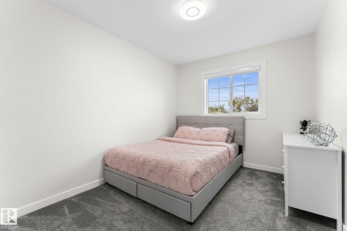 Bright room featuring a window with white trim, gray carpet, white walls, and a flush mount ceiling light fixture - 362 Blackburn Drive E, Edmonton, AB - Indoor Photo Showing Bedroom