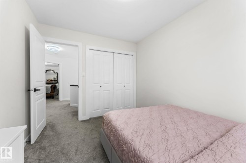 Light gray carpeted room featuring white walls, a double bifold closet, and a contemporary flush-mount ceiling light - 362 Blackburn Drive E, Edmonton, AB - Indoor Photo Showing Bedroom