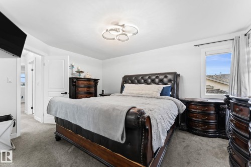Spacious bedroom featuring light gray carpeting, a contemporary ceiling light fixture, and white painted walls - 362 Blackburn Drive E, Edmonton, AB - Indoor Photo Showing Bedroom