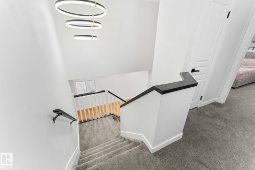 Modern interior staircase with neutral carpeting and white walls - 362 Blackburn Drive E, Edmonton, AB - Indoor Photo Showing Other Room