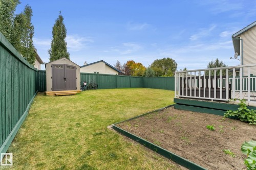 Expansive backyard featuring a manicured lawn, full privacy fencing, and a dedicated garden bed - 362 Blackburn Drive E, Edmonton, AB - Outdoor