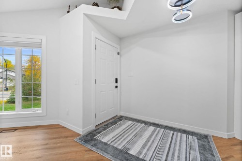 Bright entryway featuring a white paneled door, wood-finish flooring, and a large multi-pane window - 362 Blackburn Drive E, Edmonton, AB - Indoor Photo Showing Other Room