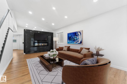 Living area featuring a floor-to-ceiling black marble-look accent wall with an integrated linear fireplace - 362 Blackburn Drive E, Edmonton, AB - Indoor Photo Showing Living Room