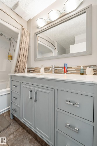 Bathroom vanity featuring a light gray finish, a white countertop, and chrome hardware - 2437 89 Street, Edmonton, AB - Indoor Photo Showing Bathroom