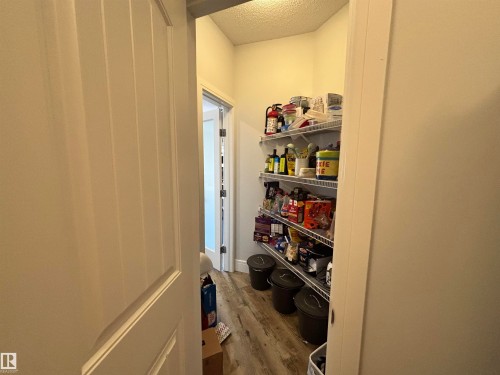 Spacious pantry featuring wire shelving, wood-finish flooring, and white paneled doors - 11 James Crescent, St. Albert, AB - Indoor Photo Showing Other Room