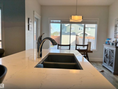 Kitchen island with a chrome faucet and integrated double basin sink - 11 James Crescent, St. Albert, AB - Indoor Photo Showing Kitchen With Double Sink