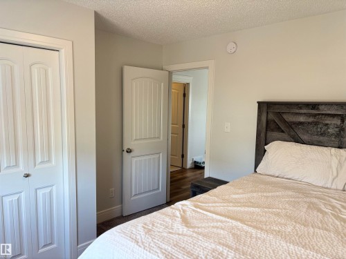 Interior room featuring neutral wall paint, white trim, white paneled doors, and textured ceiling finish - 11 James Crescent, St. Albert, AB - Indoor Photo Showing Bedroom