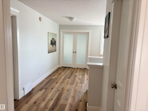 Hallway featuring wood-finish flooring, white baseboards, and white trim - 11 James Crescent, St. Albert, AB - Indoor Photo Showing Other Room