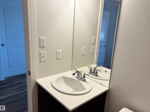 Bathroom vanity featuring an integrated white sink, chrome faucet, and expansive wall-mounted mirror - 11 James Crescent, St. Albert, AB - Indoor Photo Showing Bathroom