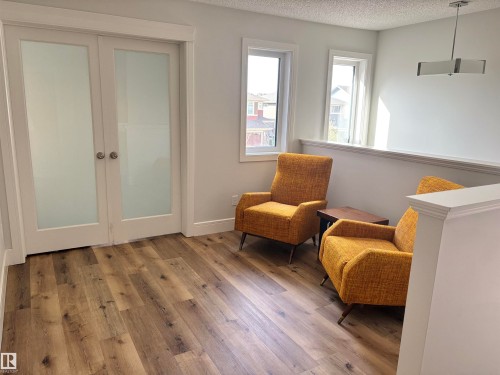 Upper-level landing featuring wood-finish flooring, white trim, and a contemporary ceiling fixture - 11 James Crescent, St. Albert, AB - Indoor